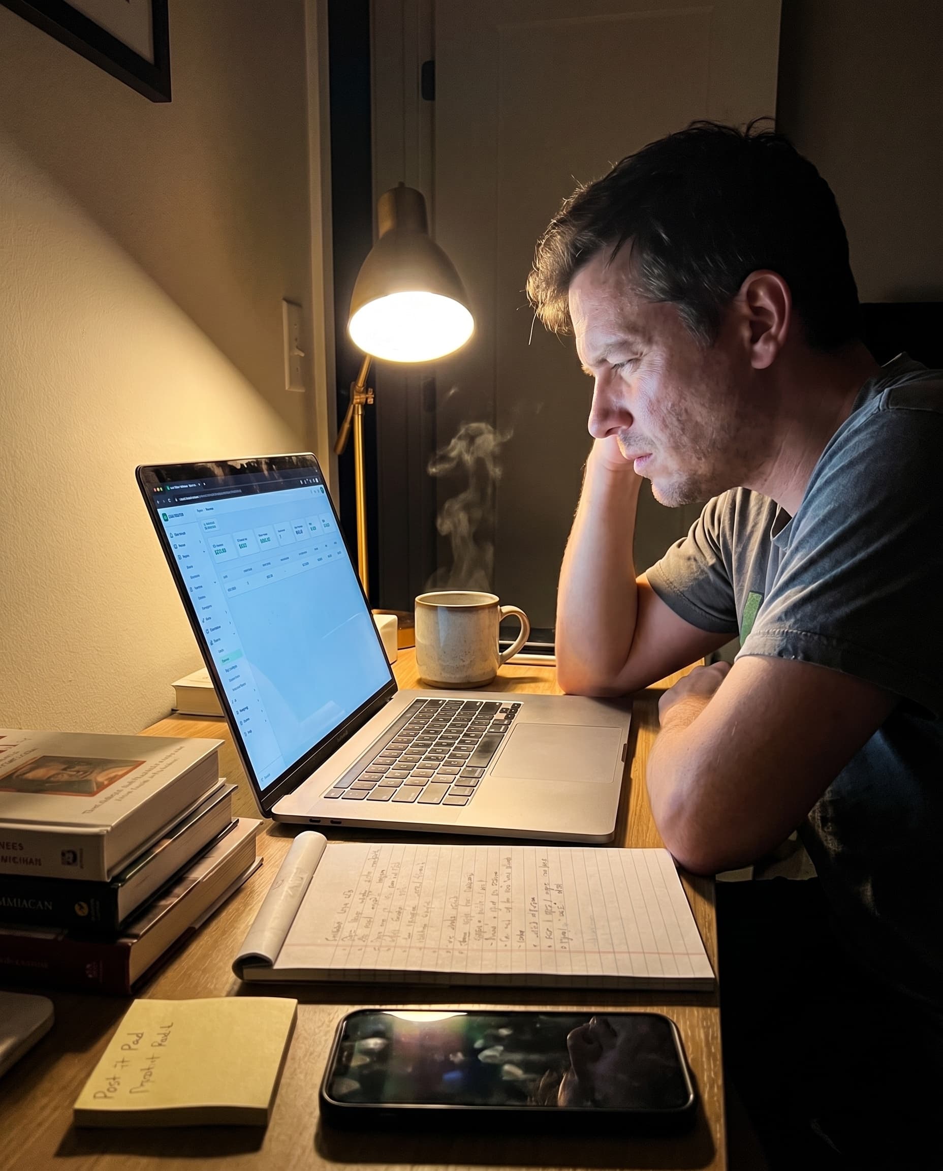 Operator reviewing Lead Router reports at a home office desk late in the evening