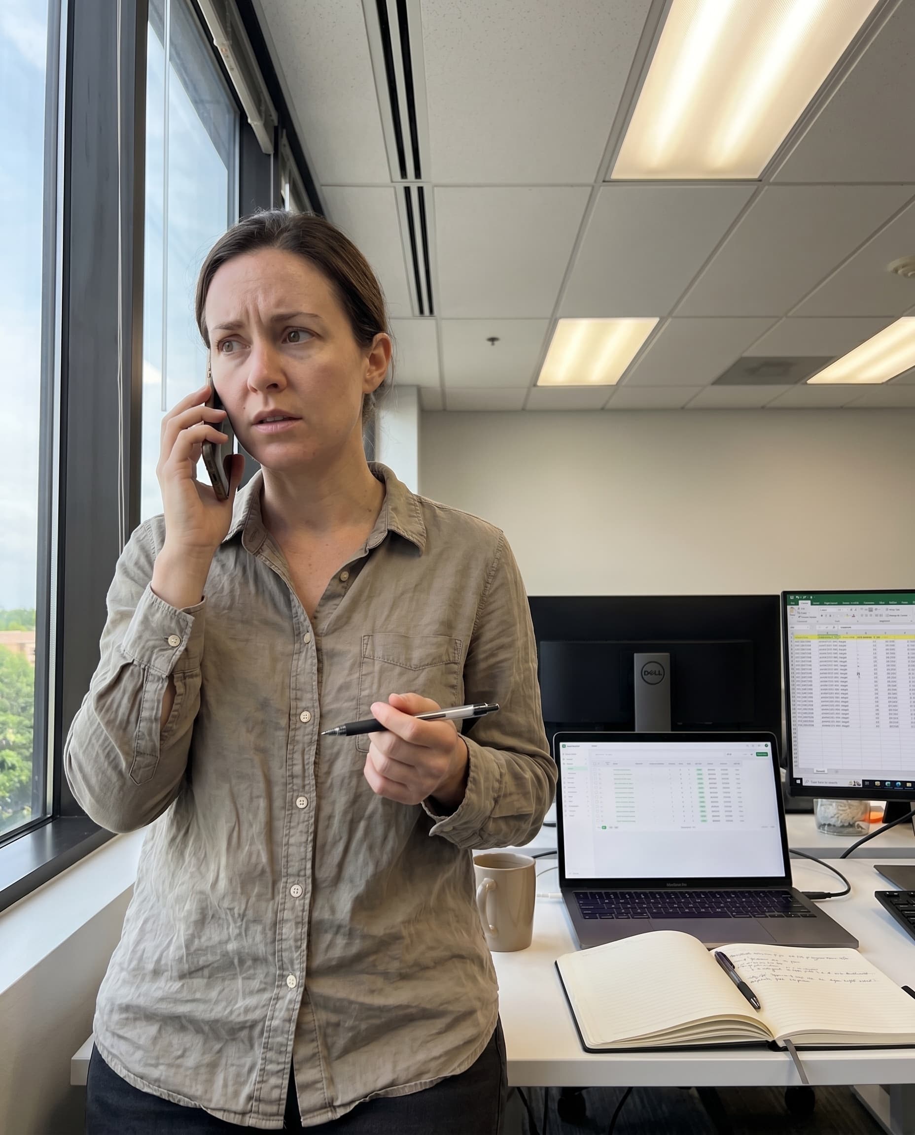 Buyer operations manager on a phone call, laptop showing Lead Router buyer pipeline